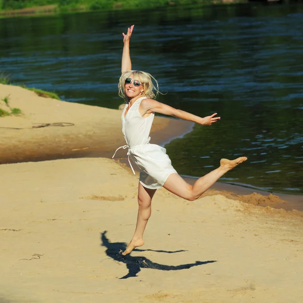Девушка счастливо прыгает по пляжу — стоковое фото