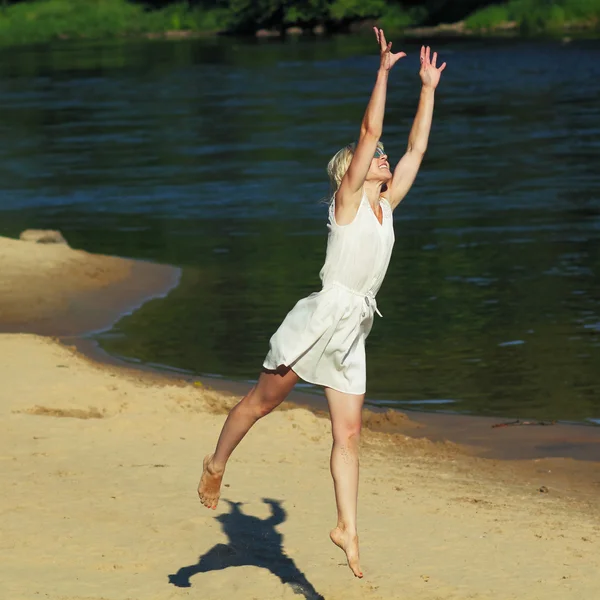 Girl happily jumping on the beach — Stock Photo, Image