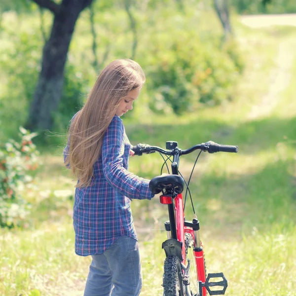 Adolescente chica con bicicleta en el campo — Foto de Stock