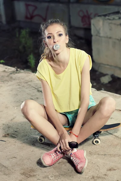 Hipster meisje, zittend op een skateboard — Stockfoto