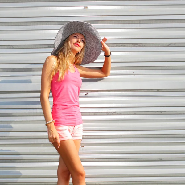 Flicka i ett hat mot metall vägg — Stockfoto