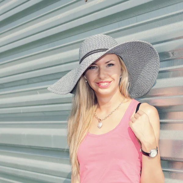 Fille dans un chapeau contre le mur en métal — Photo