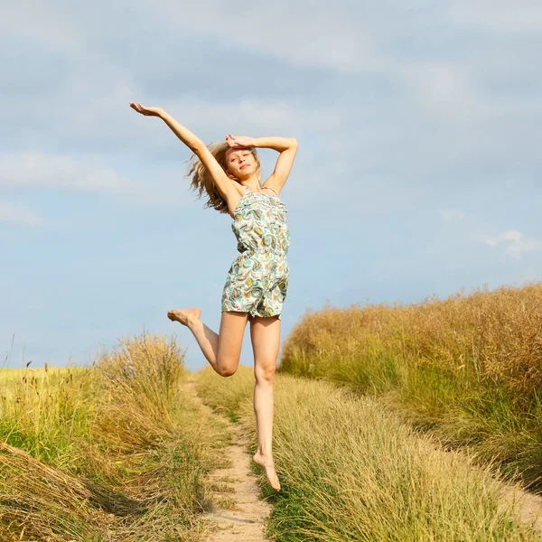 Młoda kobieta, skoki nad niebieski niebo — Zdjęcie stockowe
