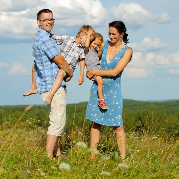 Famiglia di quattro persone che si divertono in cima alla collina — Foto Stock