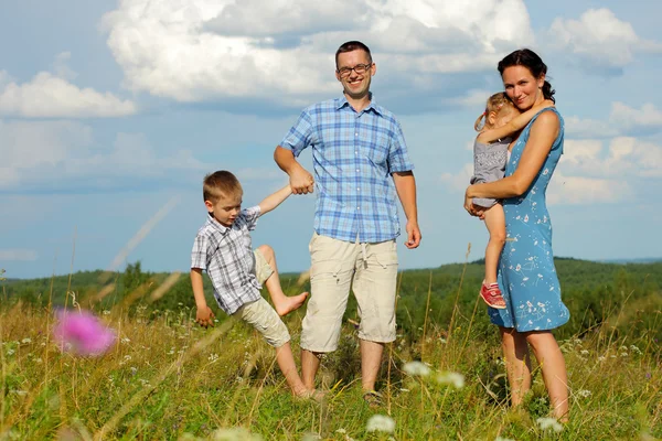 Familie van vier plezier op heuvel — Stockfoto