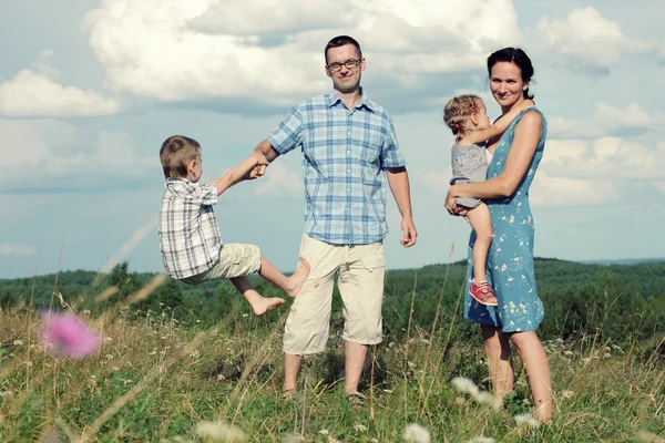 Vierköpfige Familie amüsiert sich auf Hügel — Stockfoto