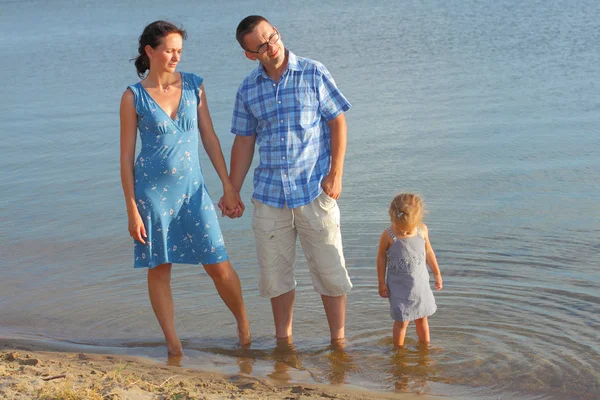 Jovem família se divertindo na praia — Fotografia de Stock