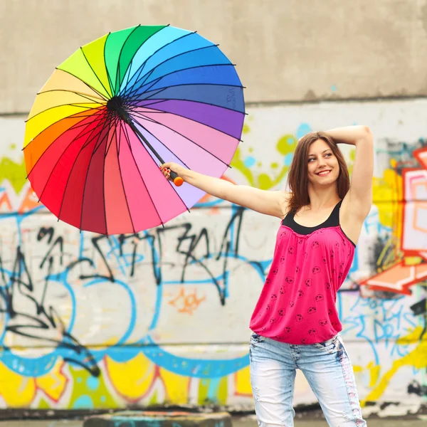 Девушка с радужным зонтиком на крыше дома — стоковое фото