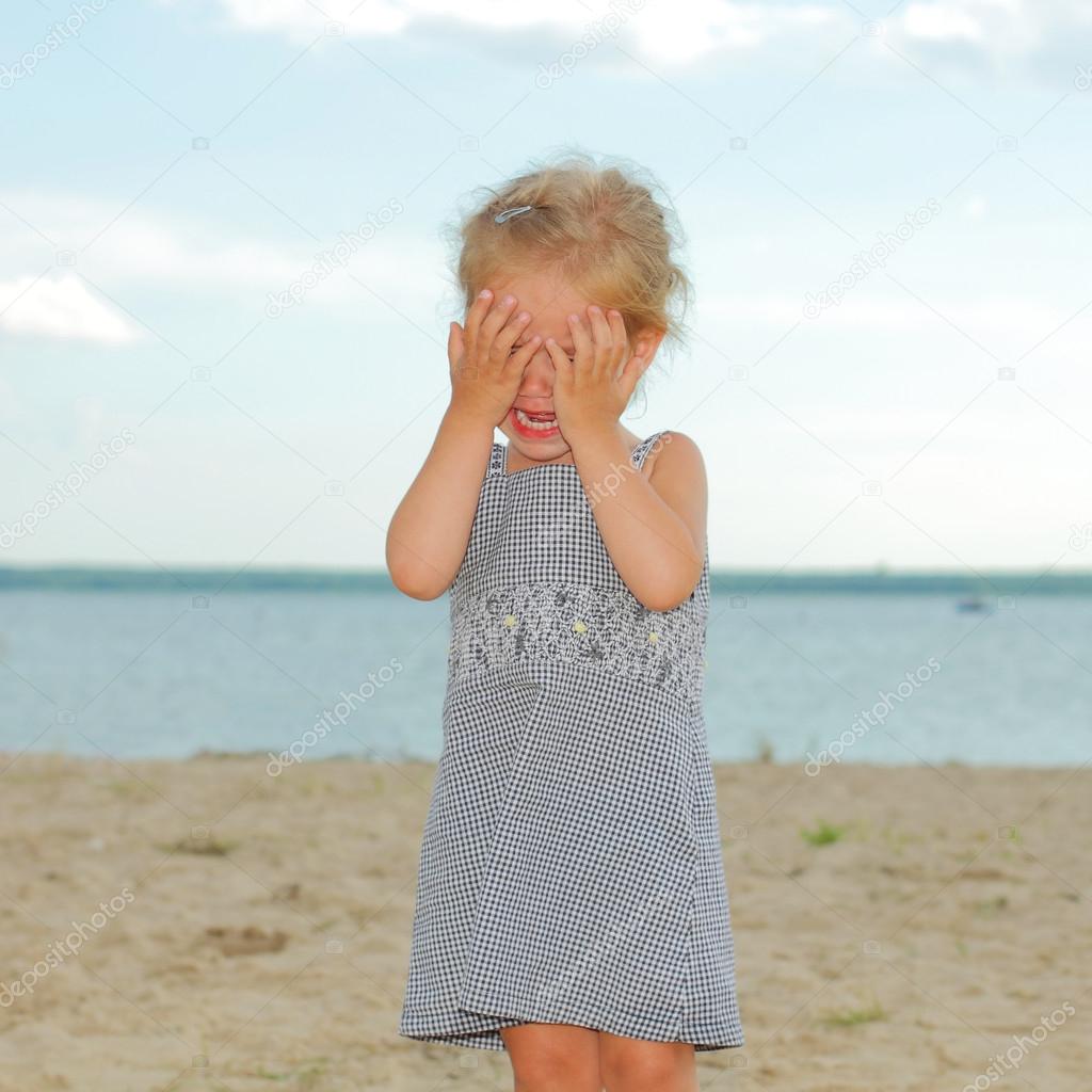 Crying little girl on the beach