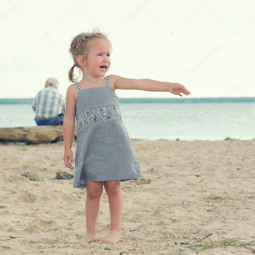 Crying little girl on the beach
