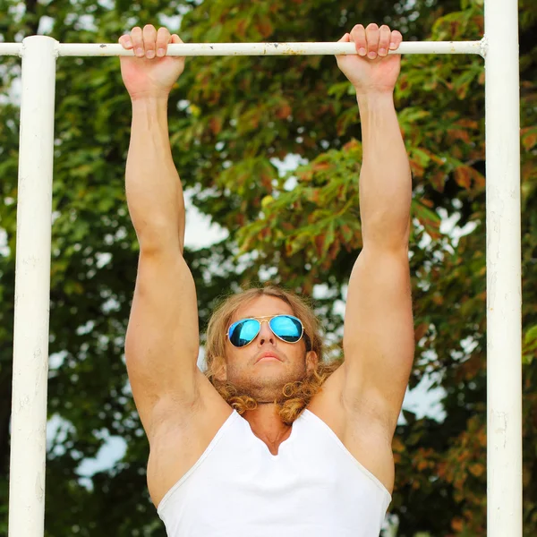 Mann turnt Übung am Barren — Stockfoto