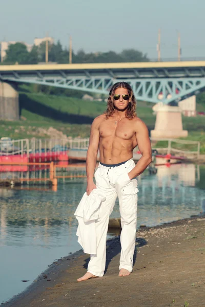 Bello fitness uomo senza maglietta sulla spiaggia — Foto Stock