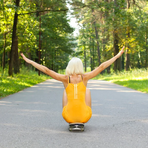 Ragazza seduta sullo skateboard — Foto Stock