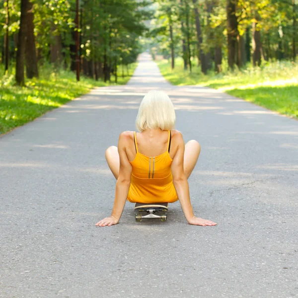 Mädchen sitzt auf Skateboard — Stockfoto