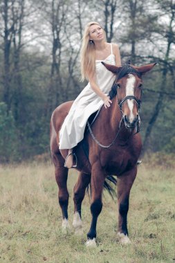 Ormandaki atlı beyaz elbiseli kız