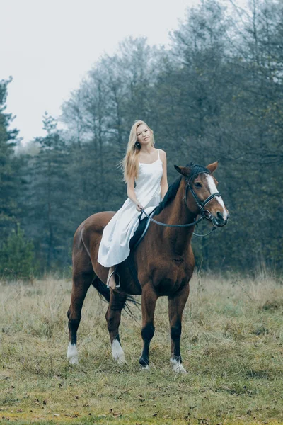 Fille en robe blanche sur un cheval dans la forêt — Photo