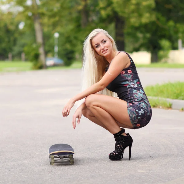 Блондинка со скейтбордом на открытом воздухе — стоковое фото