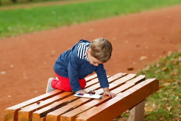 Boy with the tablet on bench — Stock Photo, Image
