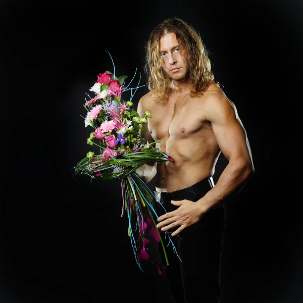 Mannelijke fitness model shirtless houden een boeket van bloemen — Stockfoto