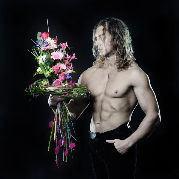 Model fitness mężczyzna przystojny, z bukietem kwiatów — Zdjęcie stockowe