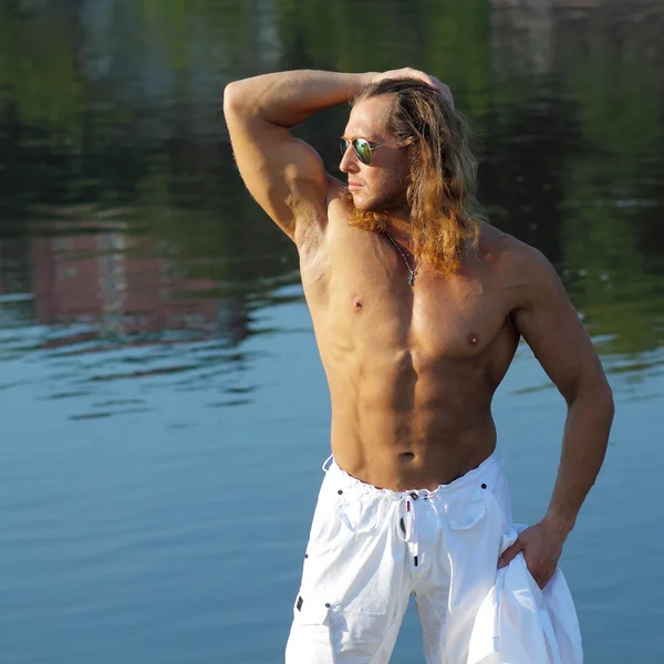 Fitness uomo in occhiali da sole sulla spiaggia — Foto Stock