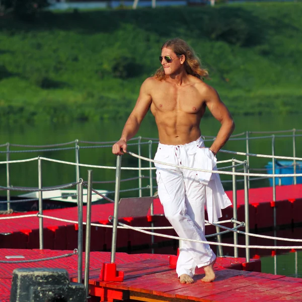 Fitness man in zonnebril op het strand — Stockfoto