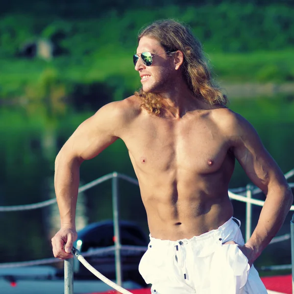 Fitness uomo in occhiali da sole sulla spiaggia — Foto Stock