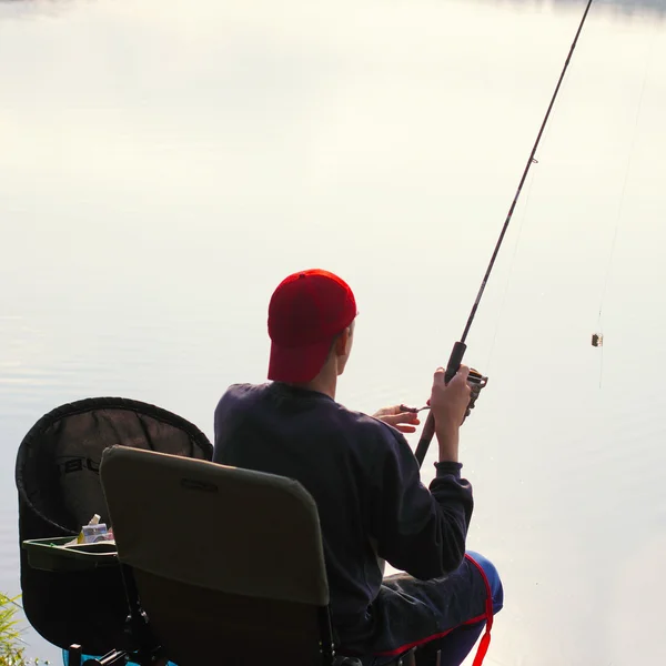 Fiskare fångar en fisk på morgonen — Stockfoto