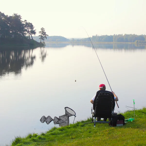 Fiskare fångar en fisk på morgonen — Stockfoto