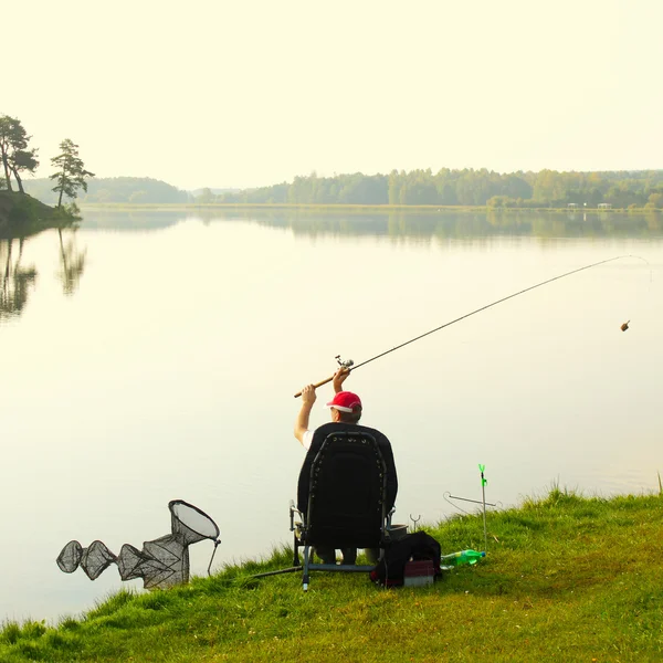 Pescador pega um peixe pela manhã — Fotografia de Stock