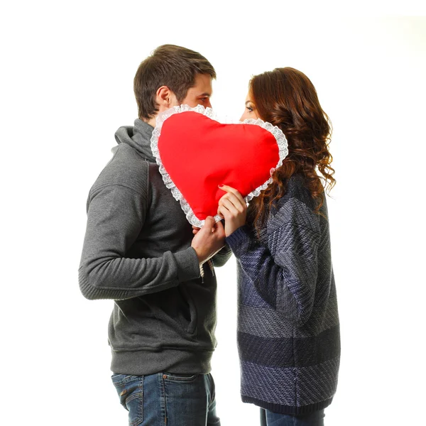 Young dates kissing behind heart — Stock Photo, Image