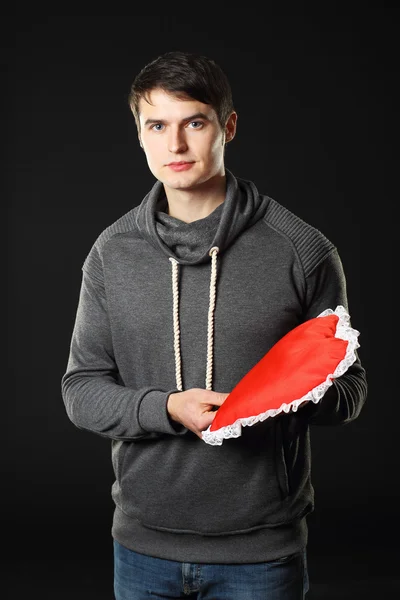 Man with a heart-shaped pillow. — Stock Photo, Image