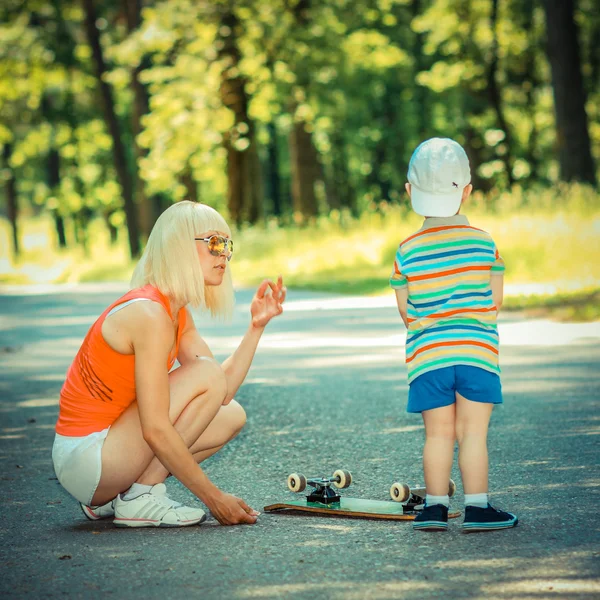 Garçon avec mère et planche à roulettes — Photo