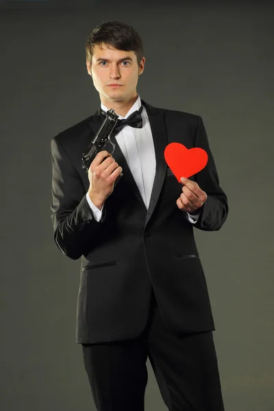 Man with heart and gun — Stock Photo, Image