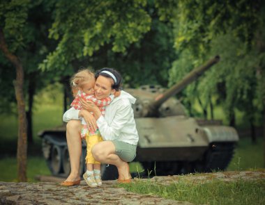 Anne ile kızı yakınındaki askeri tank
