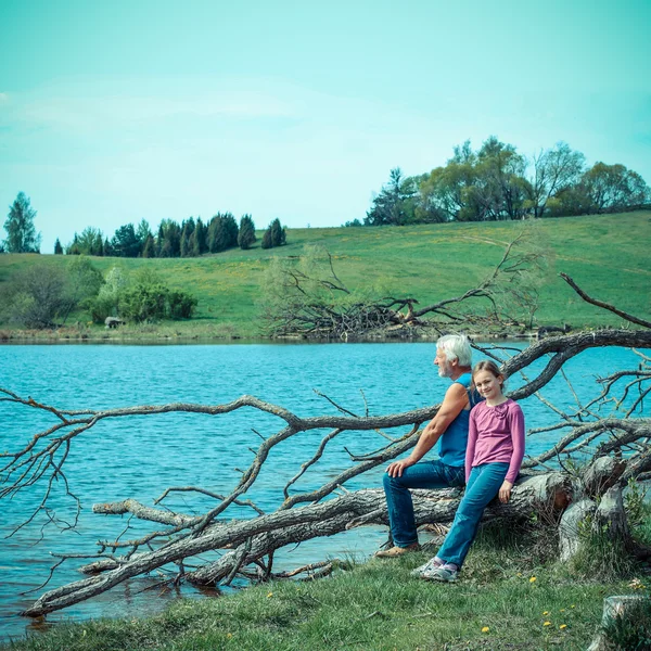 Abuelo y nieta en la naturaleza en el lago — Foto de Stock