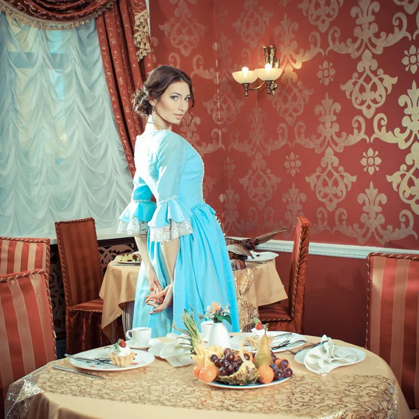 Chica en vestido vintage en la cafetería Imagen de stock