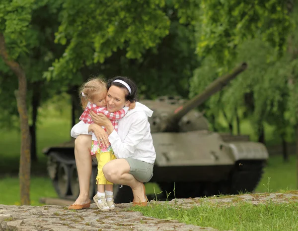 Madre con figlia vicino carro armato militare — Foto Stock