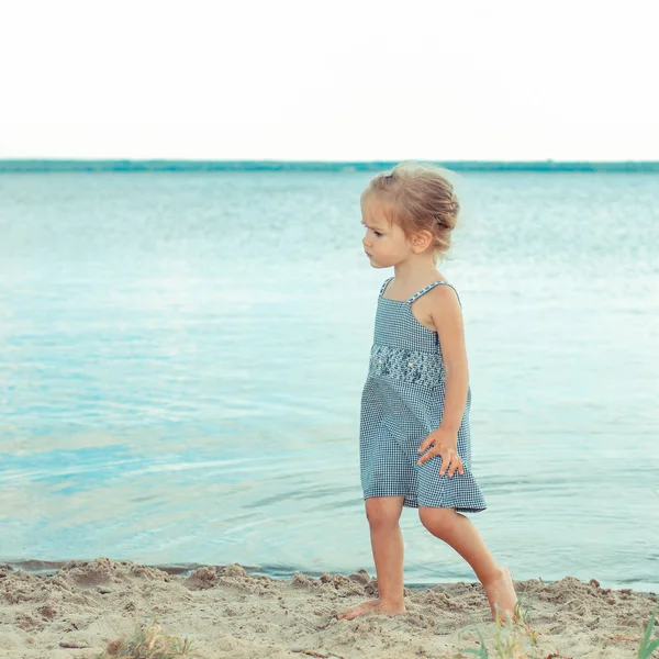 Little girl standing on the beach — Stock Photo, Image