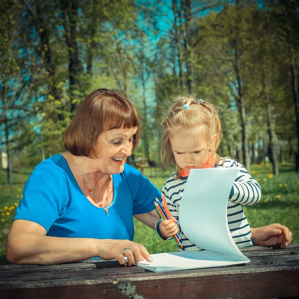 Grootmoeder en weinig kleindochter schilderen in de natuur — Stockfoto