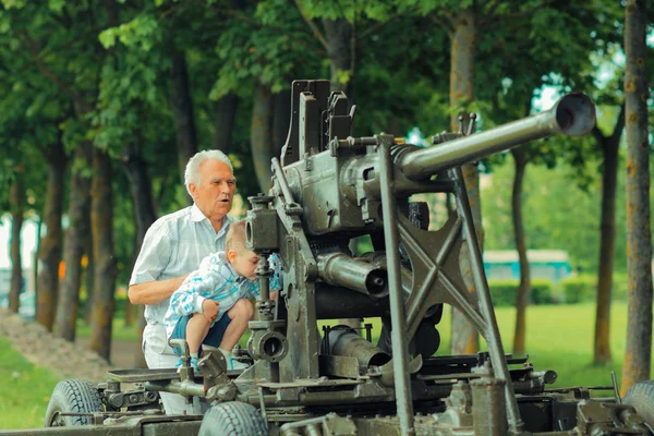 Farfar visar sonson gamla militära artilleri — Stockfoto