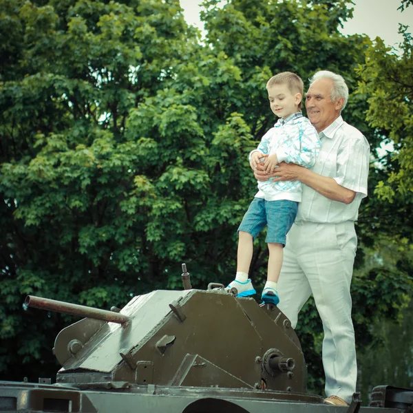 祖父が孫の古い軍砲兵に示しています — ストック写真