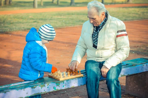 Grand-père et petit-fils jouant aux échecs — Photo