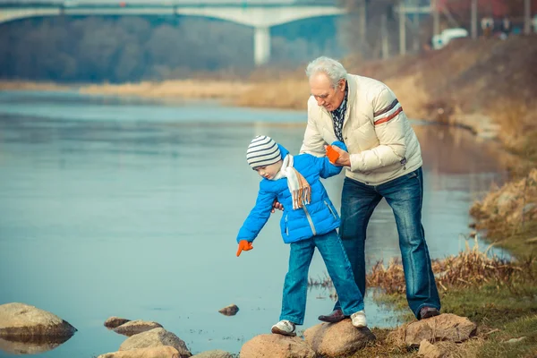 Abuelo y nieto en las piedras del río —  Fotos de Stock
