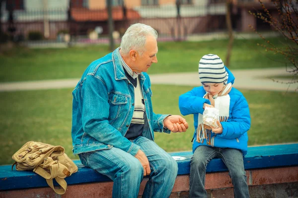 Grandfather and grandson eating fries — Stock Photo, Image