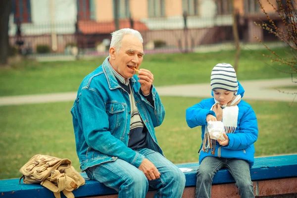 Großvater und Enkel essen Pommes — Stockfoto