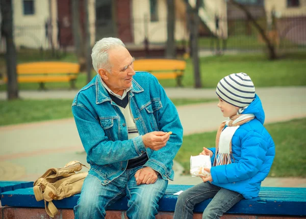 Grandfather and grandson eating fries — Stock Photo, Image