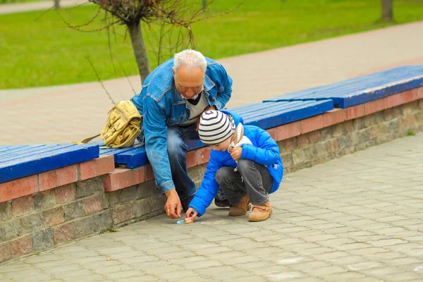 Grandfather and grandson draw with chalks — Stock Photo, Image