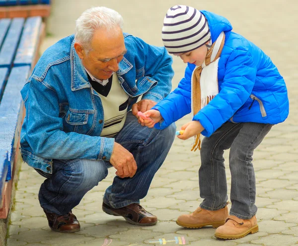 Дедушка и внук рисуют мелом. — стоковое фото