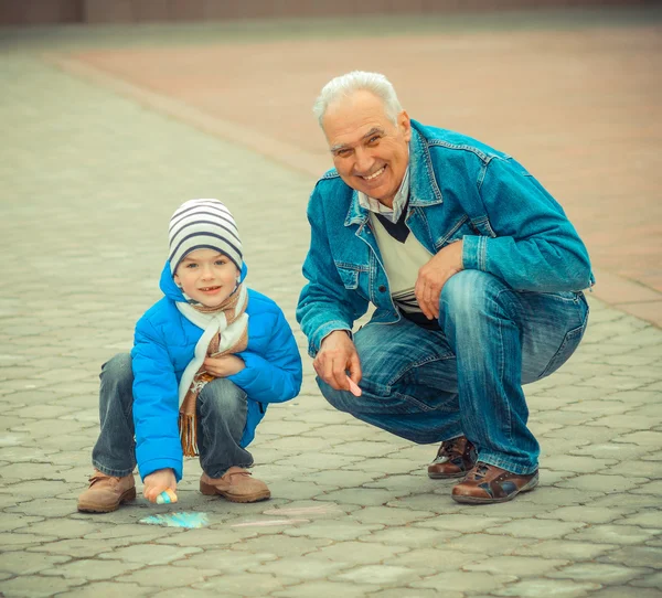 Grandfather and grandson draw with chalks — Stock Photo, Image